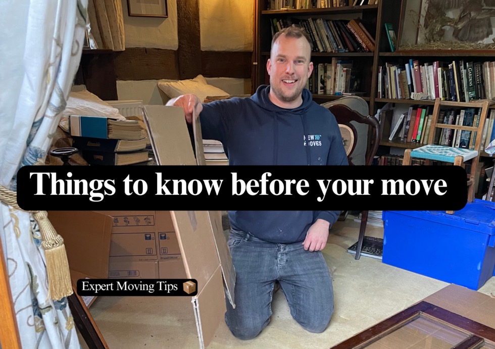 A New Moves team member kneeling beside moving boxes in a client's living room