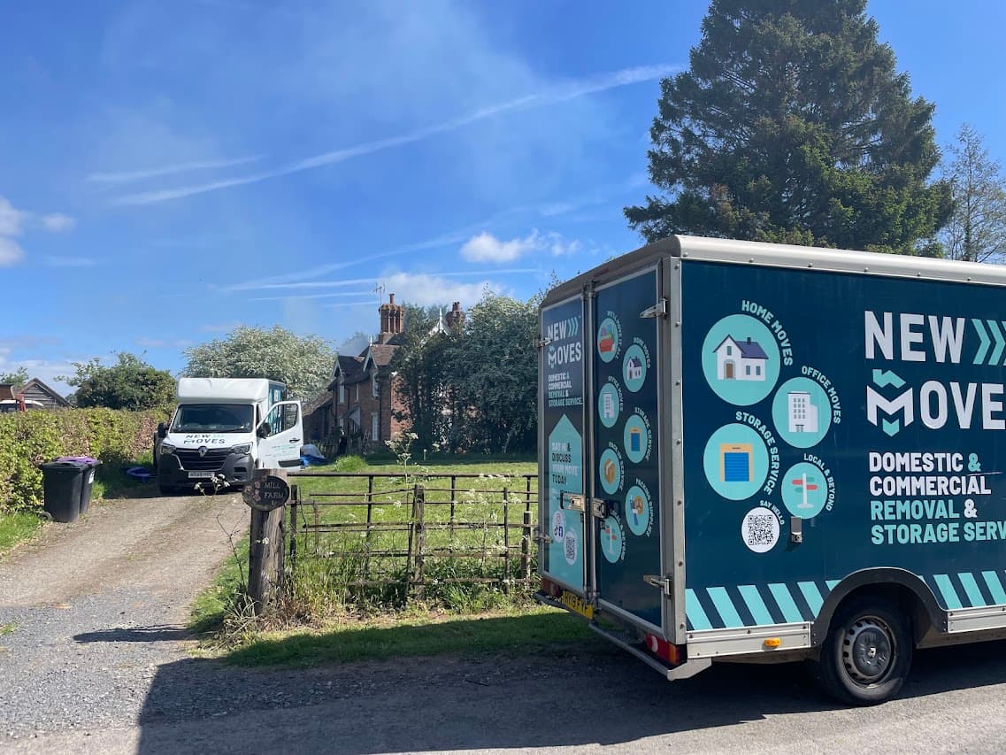 A New Moves Removals van parked at a countryside farm gate